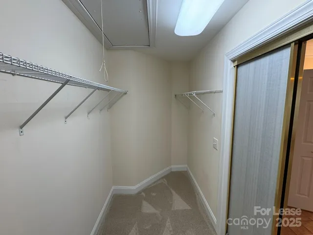 a view of walk in closet with empty racks