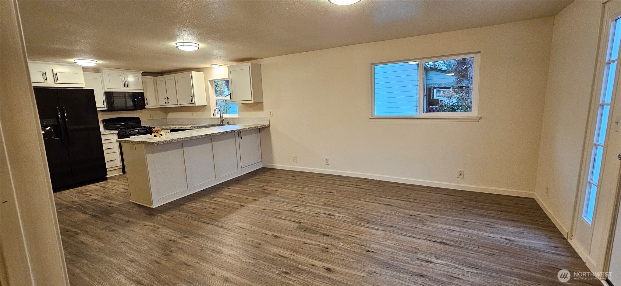 7606 Union Mills Road Southeast Lacey, WA 98503 - Photo 5 of 16 a kitchen with stainless steel appliances granite countertop a stove top oven a refrigerator a sink and dishwasher with wooden floor