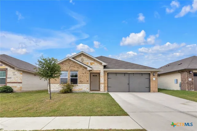 a view of a house with a yard and garage