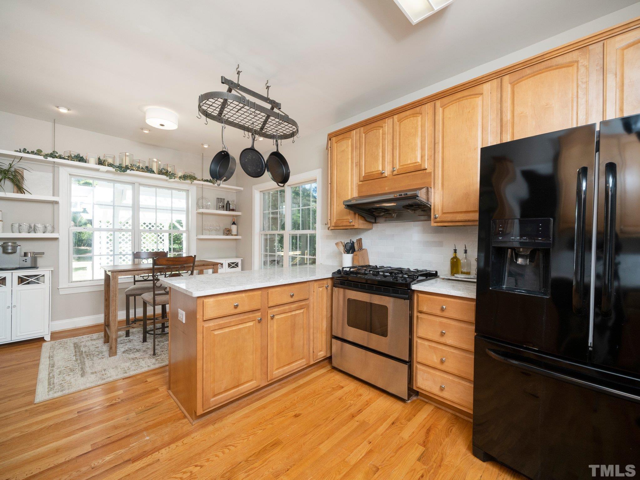 1236 Torchlight Way Raleigh, NC 27603 - Photo 11 of 39 a kitchen with stainless steel appliances granite countertop a refrigerator a stove a sink dishwasher a dining table and chairs with wooden floor