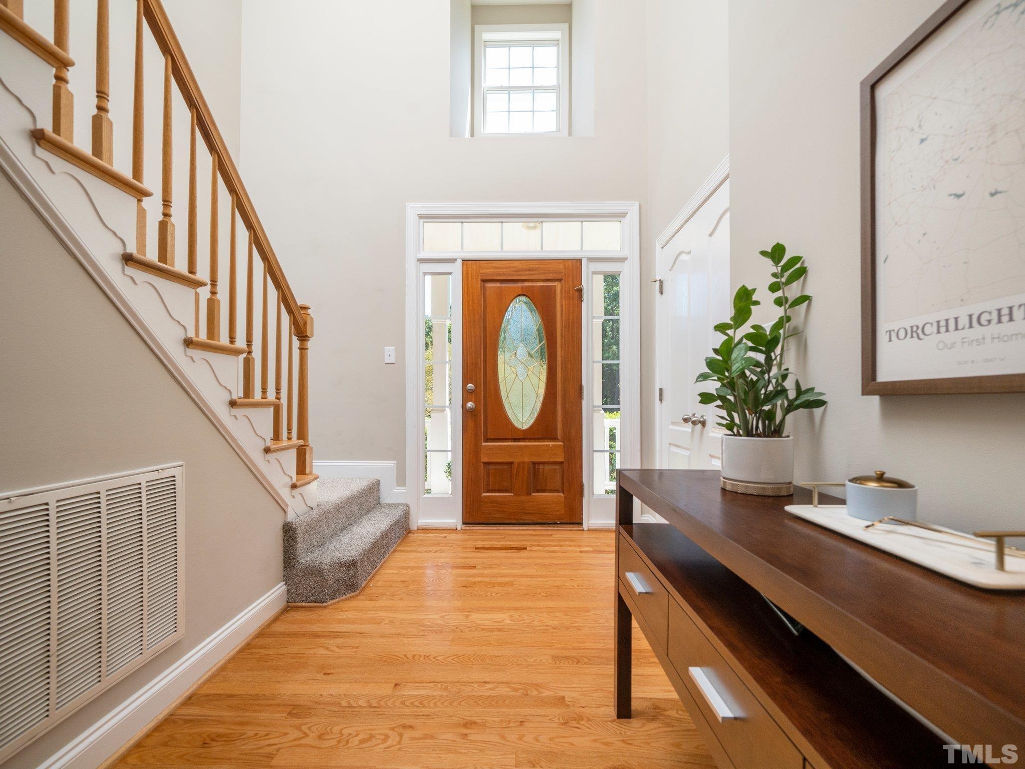 1236 Torchlight Way Raleigh, NC 27603 - Photo 3 of 39 a hallway with a potted plant on a dresser and a large window