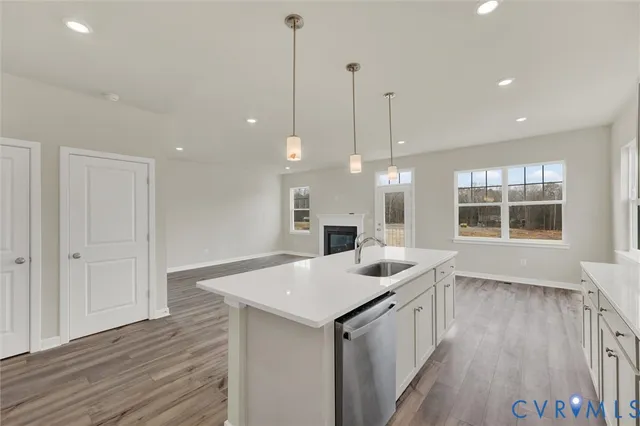 a kitchen with a sink chandelier and wooden floor