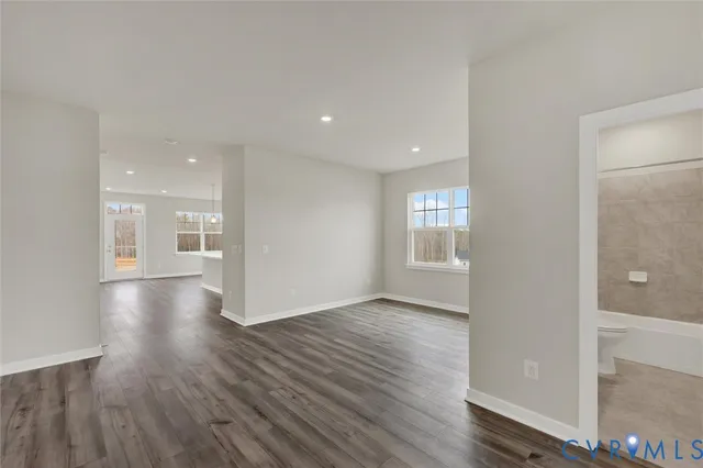 a view of a big room with wooden floor and windows