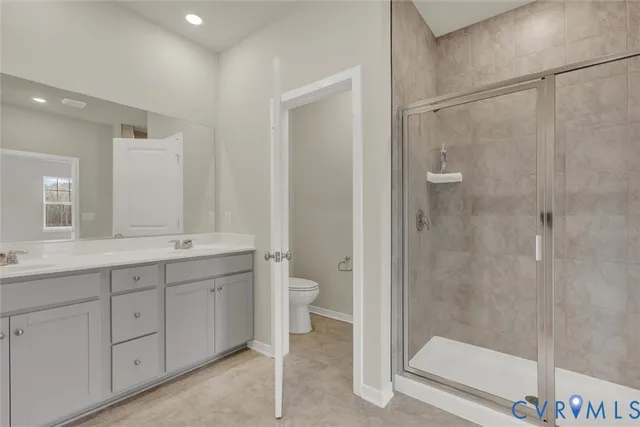 a bathroom with a double vanity sink toilet and shower