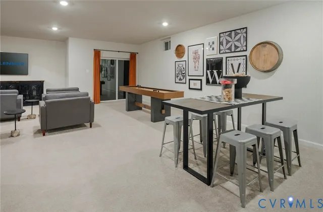 a living room with furniture a clock on wall and a flat screen tv