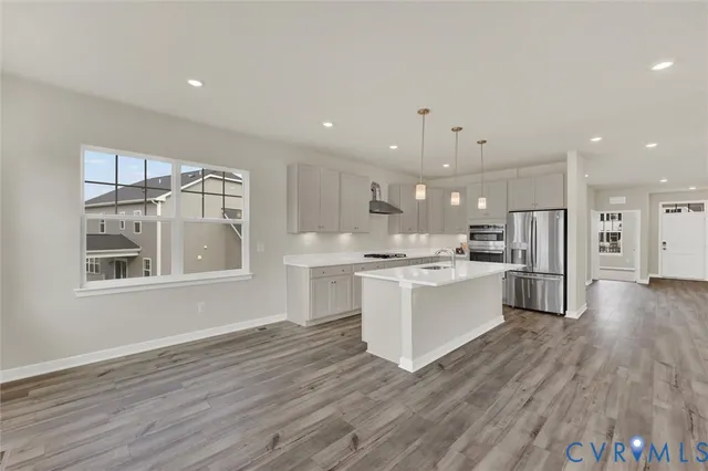 a large kitchen with kitchen island a sink stainless steel appliances and cabinets
