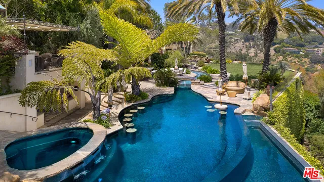 an aerial view of a house with outdoor space and swimming pool