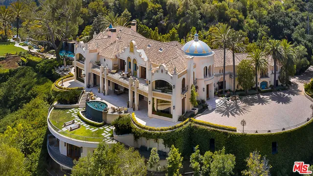 a living room with couches and a large kitchen with stainless steel appliances