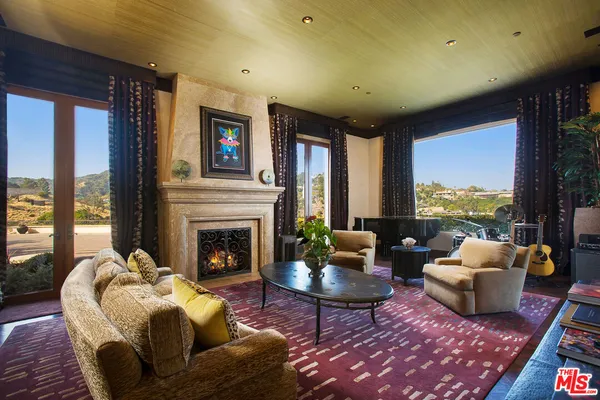 a bed sitting in a spacious bedroom next to a large window