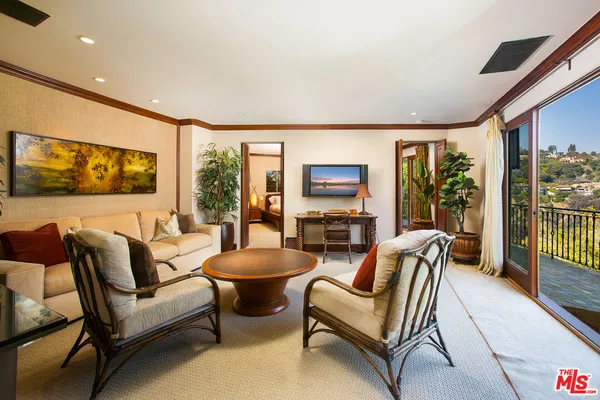 a bedroom with a bed and large windows