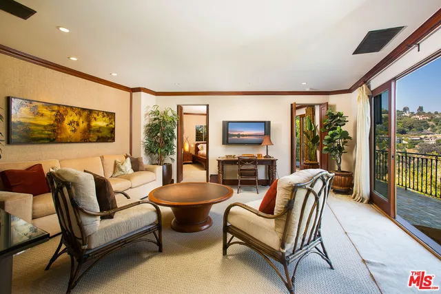 a bedroom with a bed and large windows