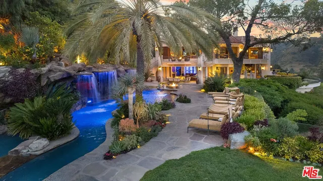a view of a backyard with plants and swimming pool
