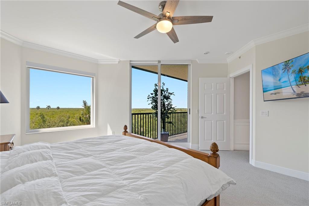 1065 Borghese Lane, Unit 403 Naples, FL 34114 - Photo 13 of 30 a bedroom with a bed and a chandelier