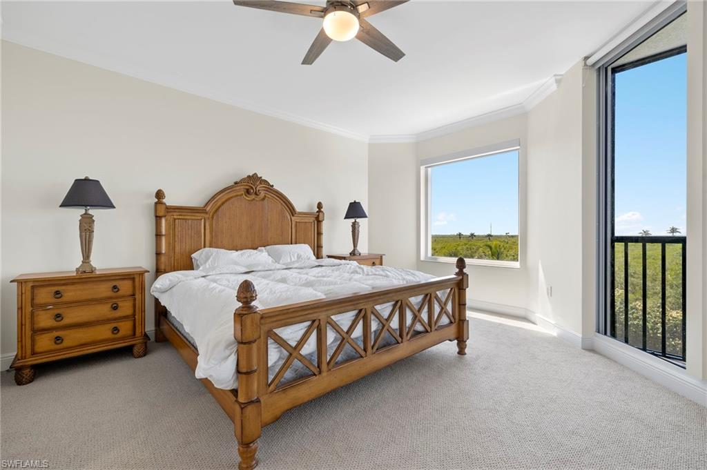 1065 Borghese Lane, Unit 403 Naples, FL 34114 - Photo 14 of 30 a spacious bedroom with a bed and a chandelier
