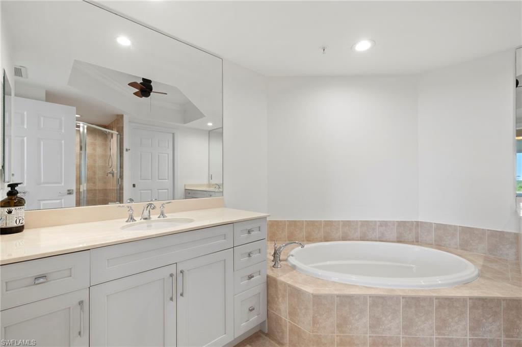 1065 Borghese Lane, Unit 403 Naples, FL 34114 - Photo 16 of 30 a bathroom with a double vanity sink and mirror