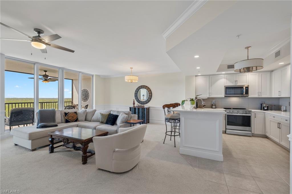 1065 Borghese Lane, Unit 403 Naples, FL 34114 - Photo 2 of 30 a living room with furniture a kitchen view and a appliances