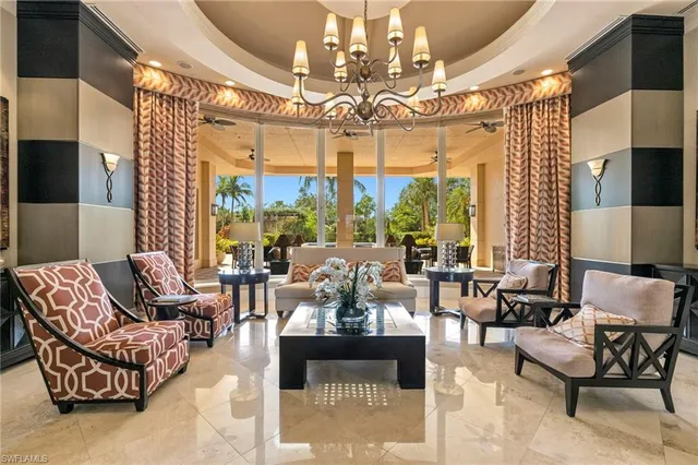 a living room with patio furniture and a chandelier