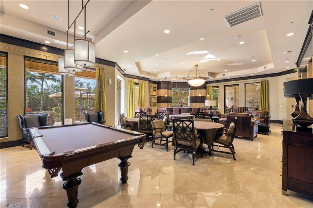 1065 Borghese Lane, Unit 403 Naples, FL 34114 - Photo 29 of 30 a large dining space with furniture a rug and a chandelier
