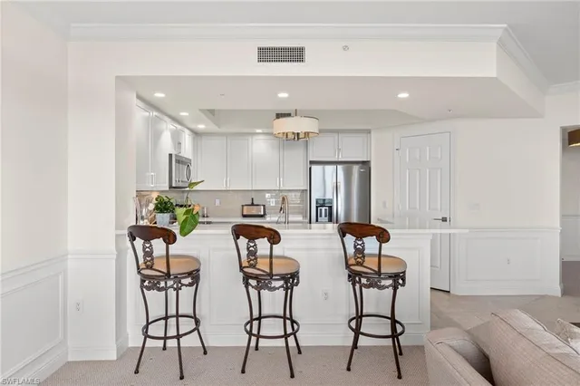 a view of a dining room with furniture and a chandelier