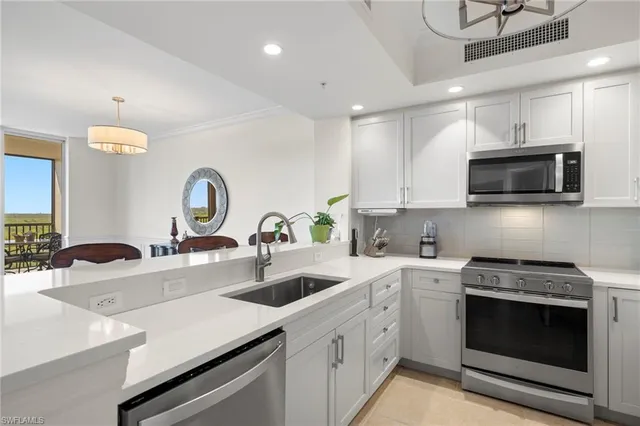 a kitchen with kitchen island a sink stainless steel appliances and cabinets