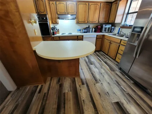 a view of kitchen with sink and wooden floor