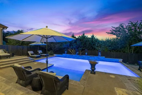 a patio with swimming pool table and chairs