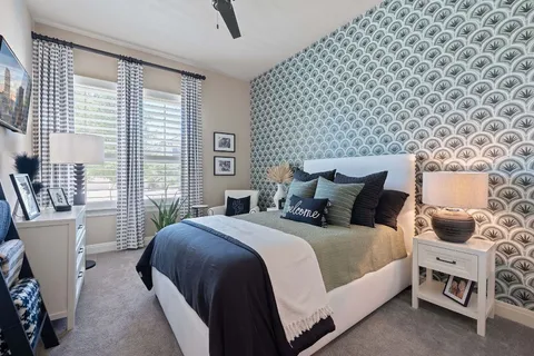 a spacious bedroom with a bed and a chandelier