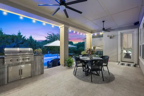 a view of a dining room with furniture a chandelier and a floor to ceiling window