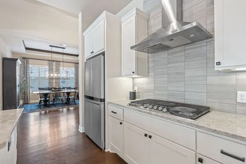a kitchen with white cabinets and appliances
