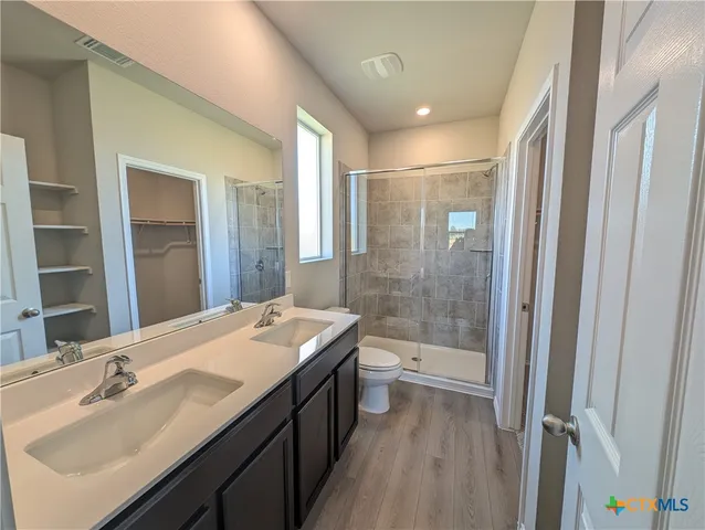 a bathroom with a double vanity sink toilet mirror and bathtub