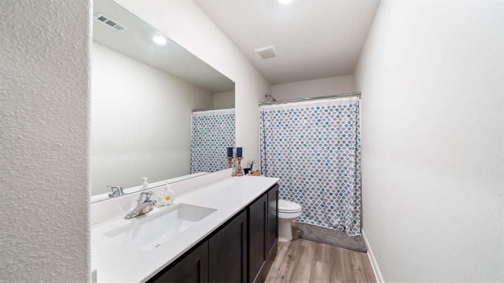 408 Micah Lane Ferris, TX 75125 - Photo 14 of 19 a bathroom with a sink a toilet and a mirror