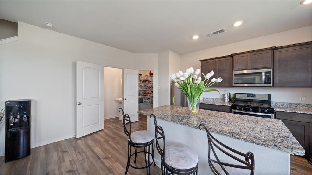 408 Micah Lane Ferris, TX 75125 - Photo 6 of 19 a kitchen with stainless steel appliances granite countertop a sink a stove a microwave a counter top space and cabinets