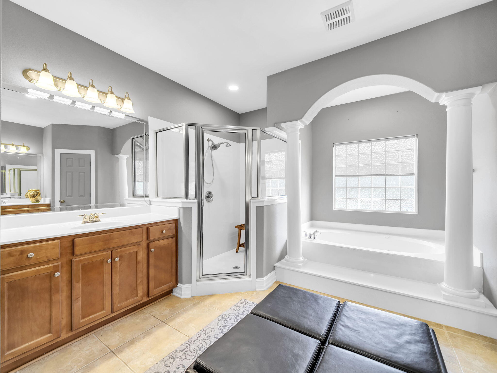 180 Gulf Pines Court Freeport, FL 32439 - Photo 23 of 70 a spacious bathroom with a double vanity sink a large mirror and a bathtub