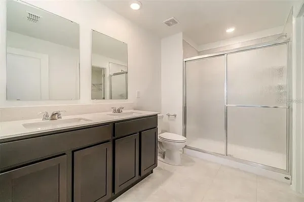 a bathroom with a double vanity sink mirror and toilet
