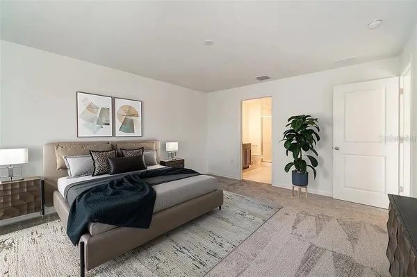 a bedroom with a bed and a potted plant