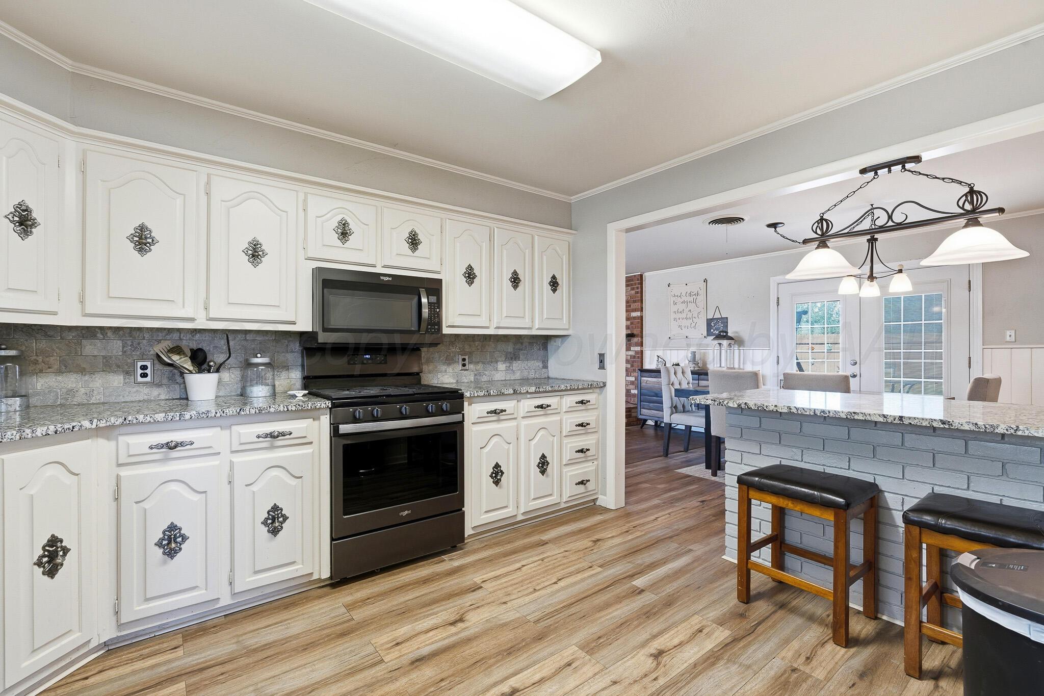 700 West Cleveland Street Dimmitt, TX 79027 - Photo 13 of 40 a kitchen with stainless steel appliances granite countertop a stove and cabinets