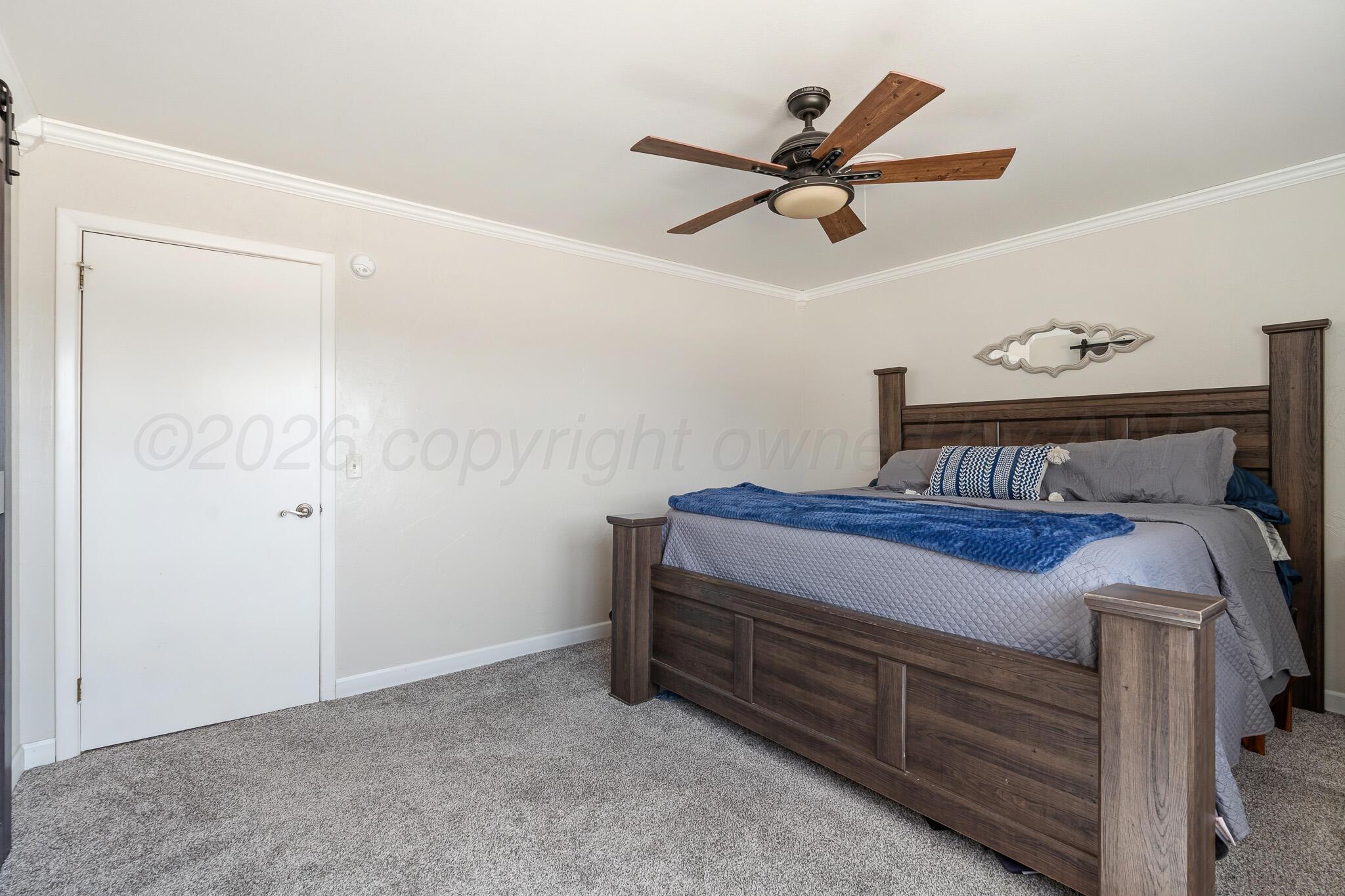 700 West Cleveland Street Dimmitt, TX 79027 - Photo 16 of 40 a bedroom with a bed and a ceiling fan