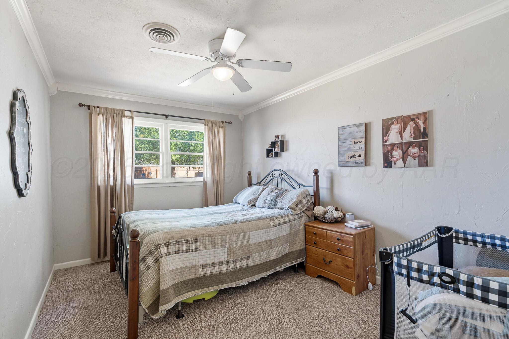700 West Cleveland Street Dimmitt, TX 79027 - Photo 25 of 40 a bedroom with a bed and a chandelier