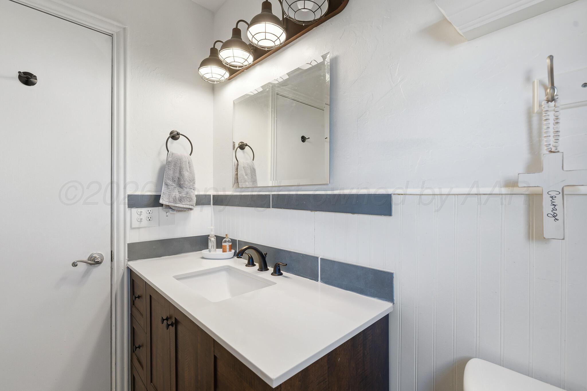 700 West Cleveland Street Dimmitt, TX 79027 - Photo 26 of 40 a bathroom with a sink vanity and a mirror