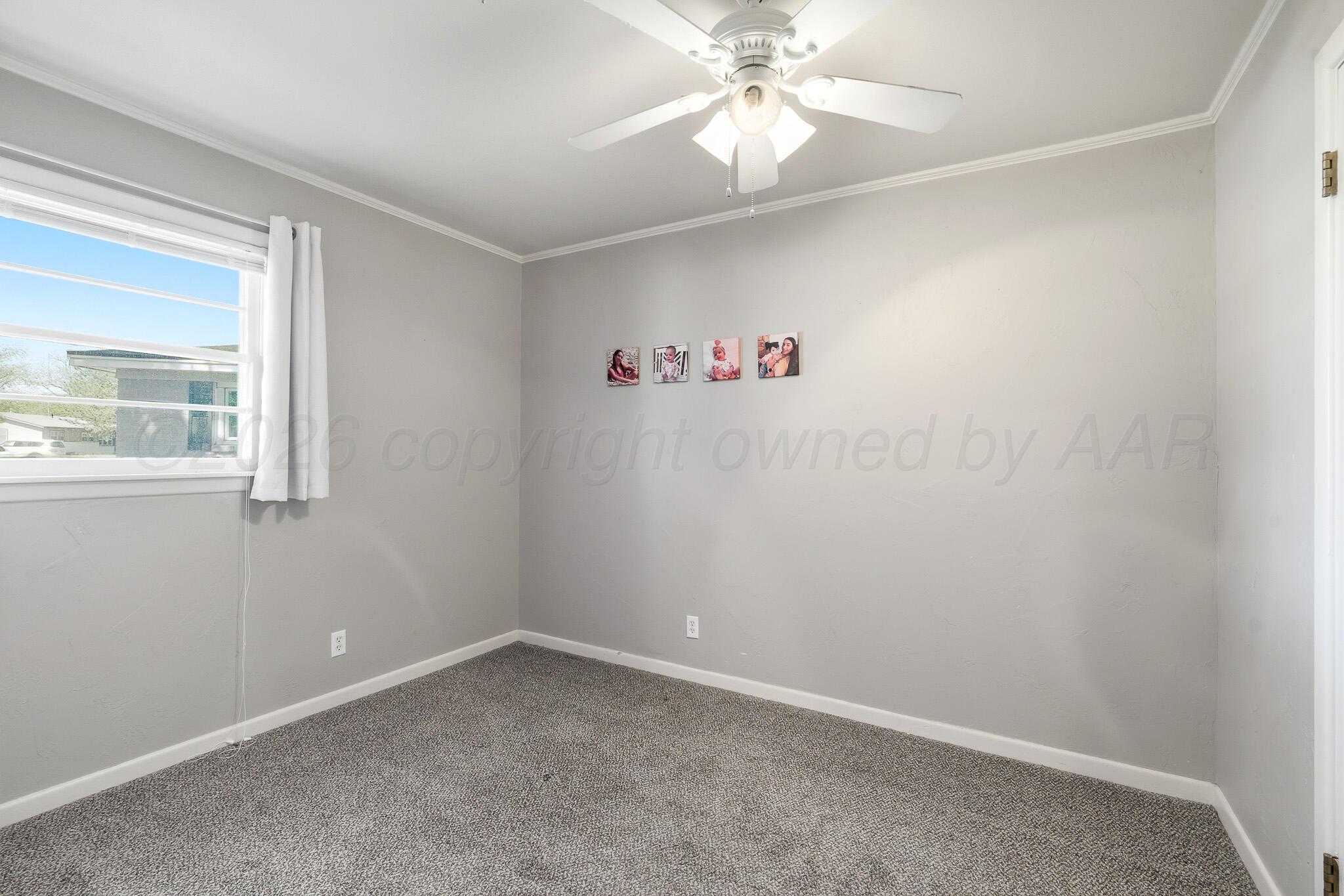 700 West Cleveland Street Dimmitt, TX 79027 - Photo 29 of 40 an empty room with a window and a fan