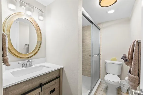 a bathroom with a toilet a sink a mirror and a shower