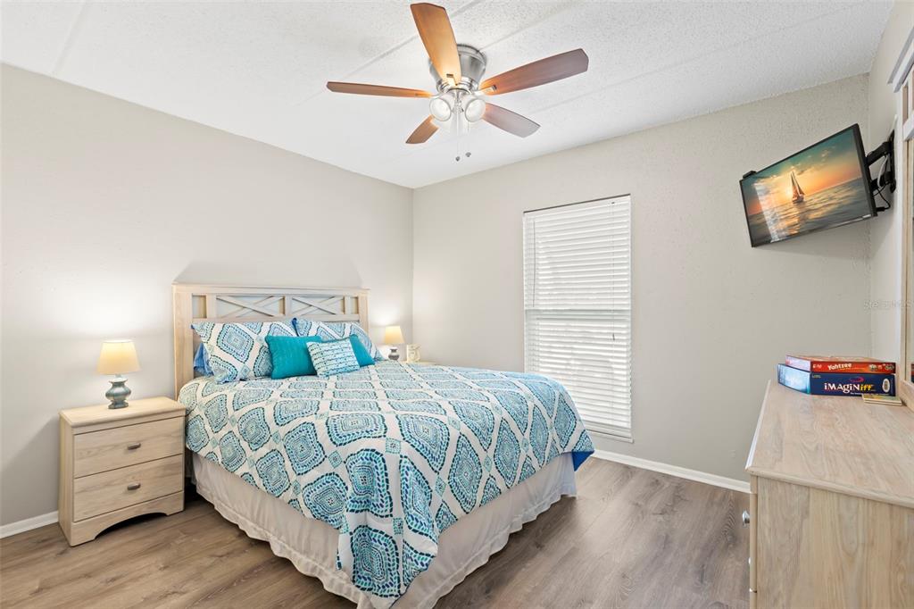 8911 Blind Pass Road, Unit 214 St. Pete Beach, FL 33706 - Photo 15 of 35 a bedroom with a bed and a tv on the dresser