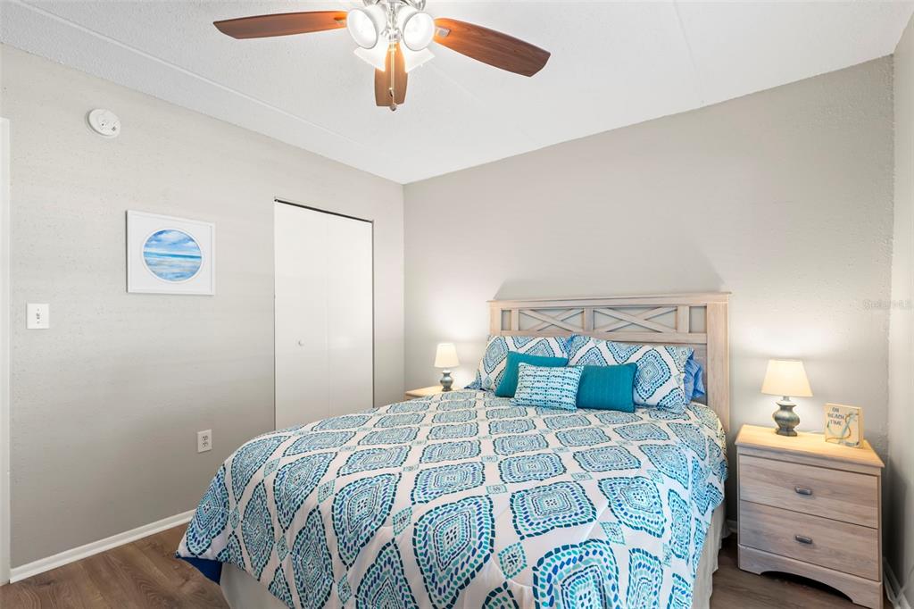 8911 Blind Pass Road, Unit 214 St. Pete Beach, FL 33706 - Photo 16 of 35 a bedroom with a bed and a chandelier