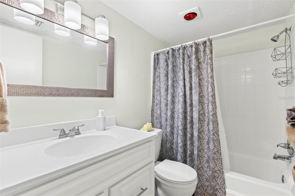 8911 Blind Pass Road, Unit 214 St. Pete Beach, FL 33706 - Photo 17 of 35 a bathroom with a sink toilet and shower