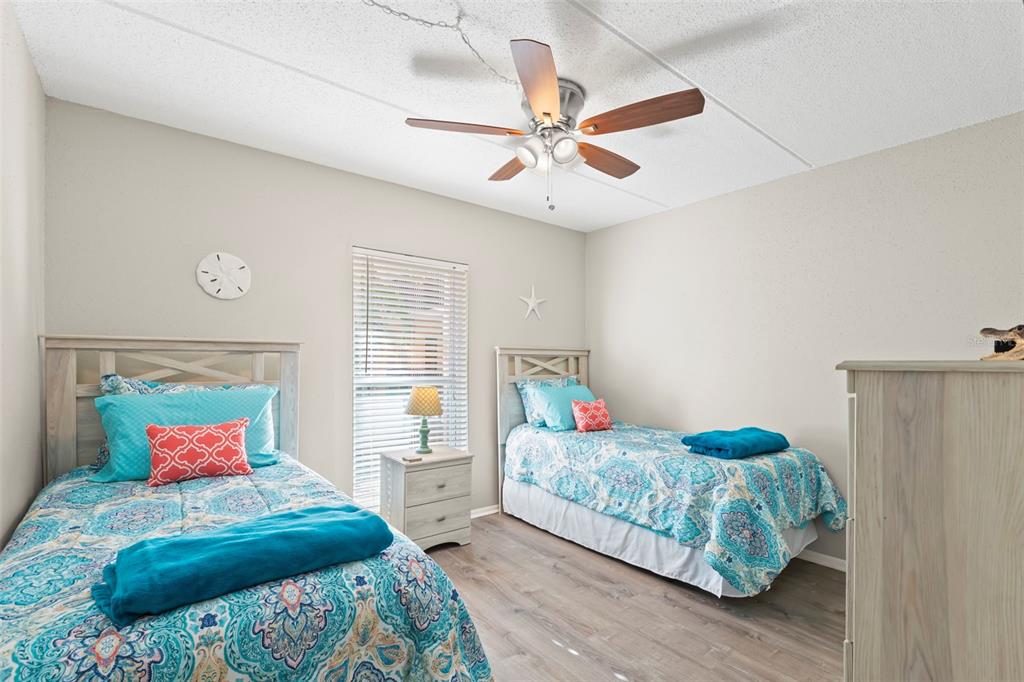 8911 Blind Pass Road, Unit 214 St. Pete Beach, FL 33706 - Photo 18 of 35 a bedroom with a bed and a chandelier