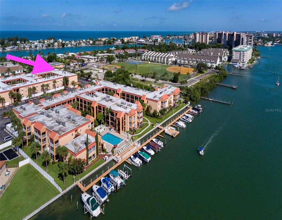 8911 Blind Pass Road, Unit 214 St. Pete Beach, FL 33706 - Photo 27 of 35 an aerial view of a house with a garden and lake view