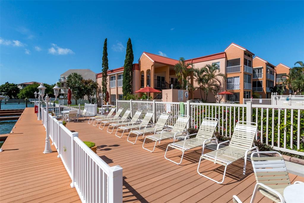 8911 Blind Pass Road, Unit 214 St. Pete Beach, FL 33706 - Photo 28 of 35 a view of a patio with couches chairs and wooden floor