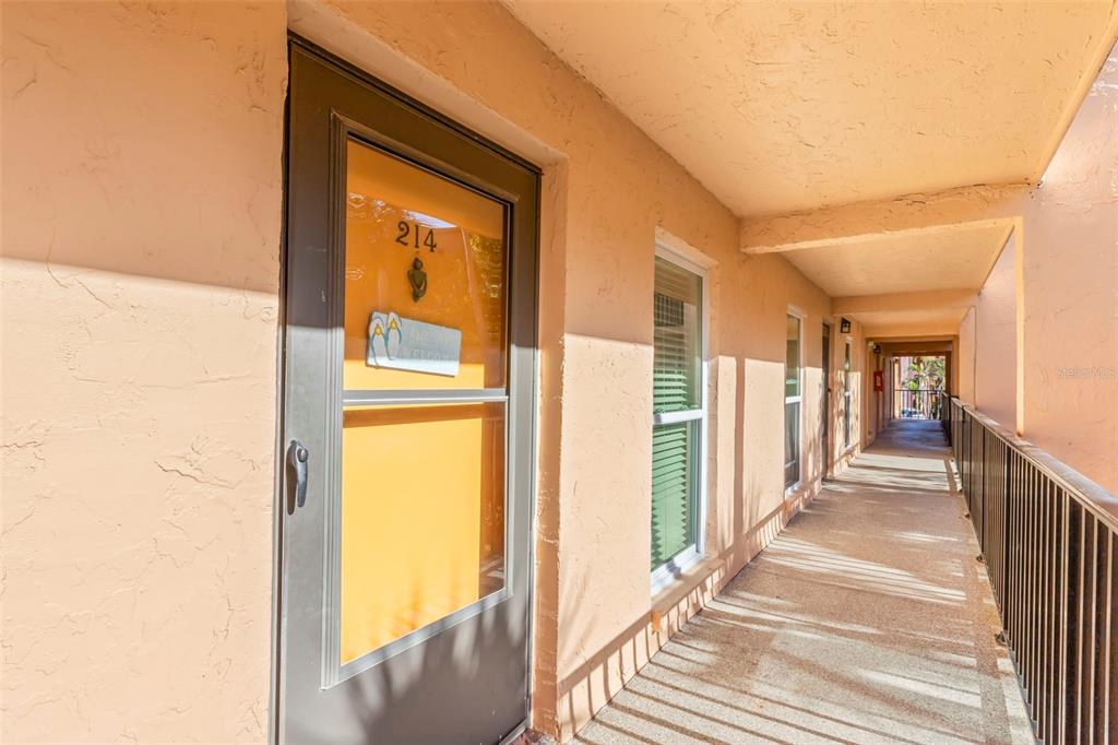 8911 Blind Pass Road, Unit 214 St. Pete Beach, FL 33706 - Photo 5 of 35 a view of a hallway with wooden floor and staircase