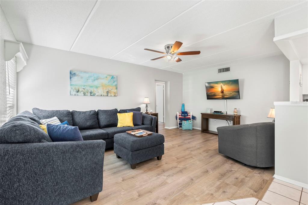 8911 Blind Pass Road, Unit 214 St. Pete Beach, FL 33706 - Photo 6 of 35 a living room with furniture and a flat screen tv