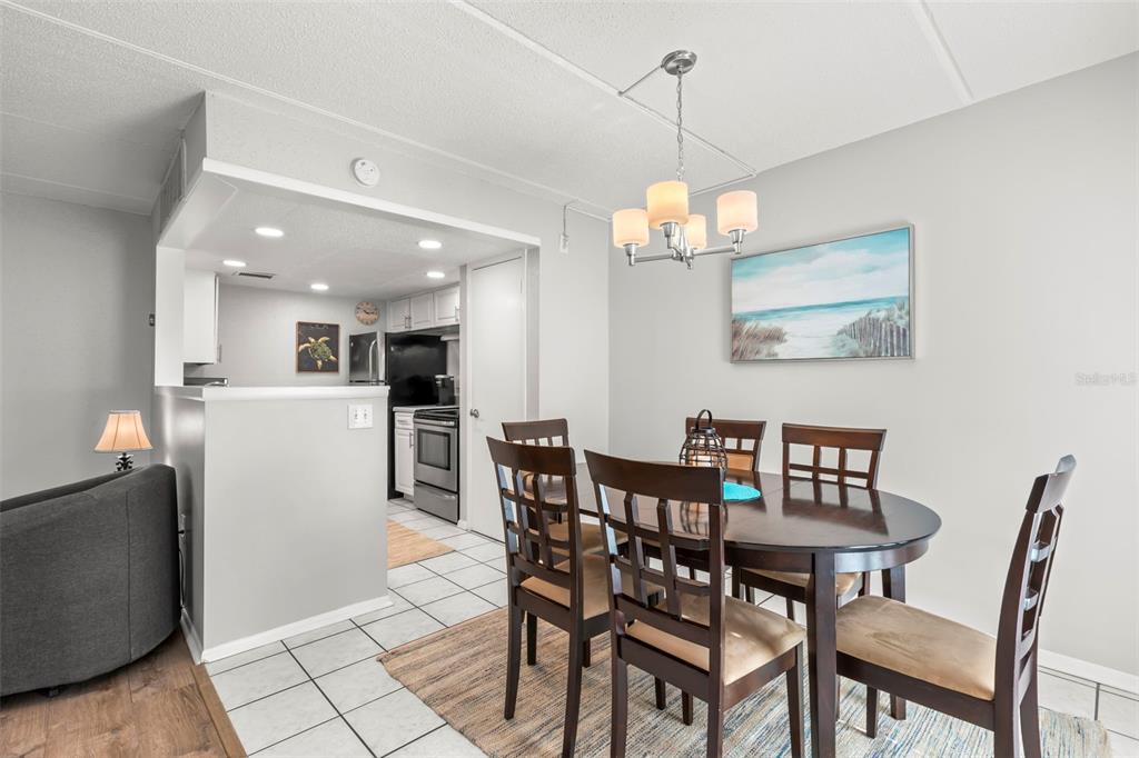 8911 Blind Pass Road, Unit 214 St. Pete Beach, FL 33706 - Photo 8 of 35 a view of a dining room with furniture and wooden floor